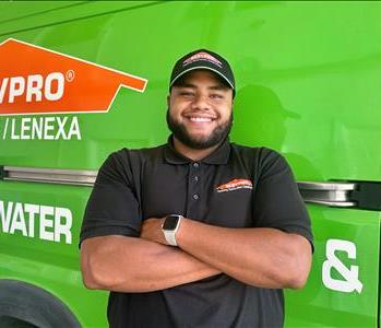 Man standing in front of green vehicle 